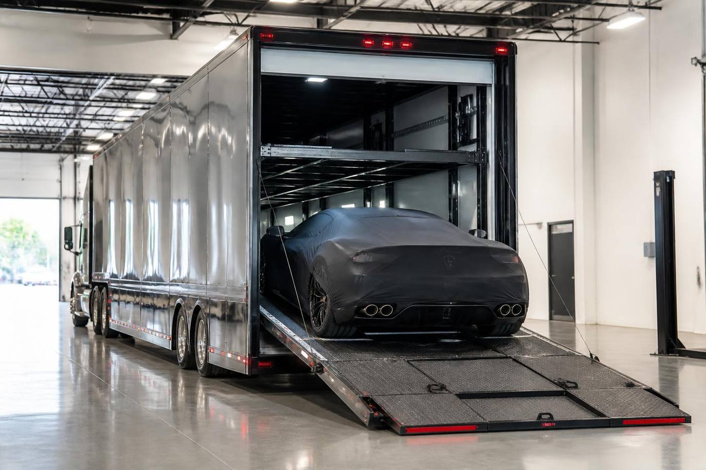Enclosed car hauler with sealed walls and roof protecting a luxury vehicle inside